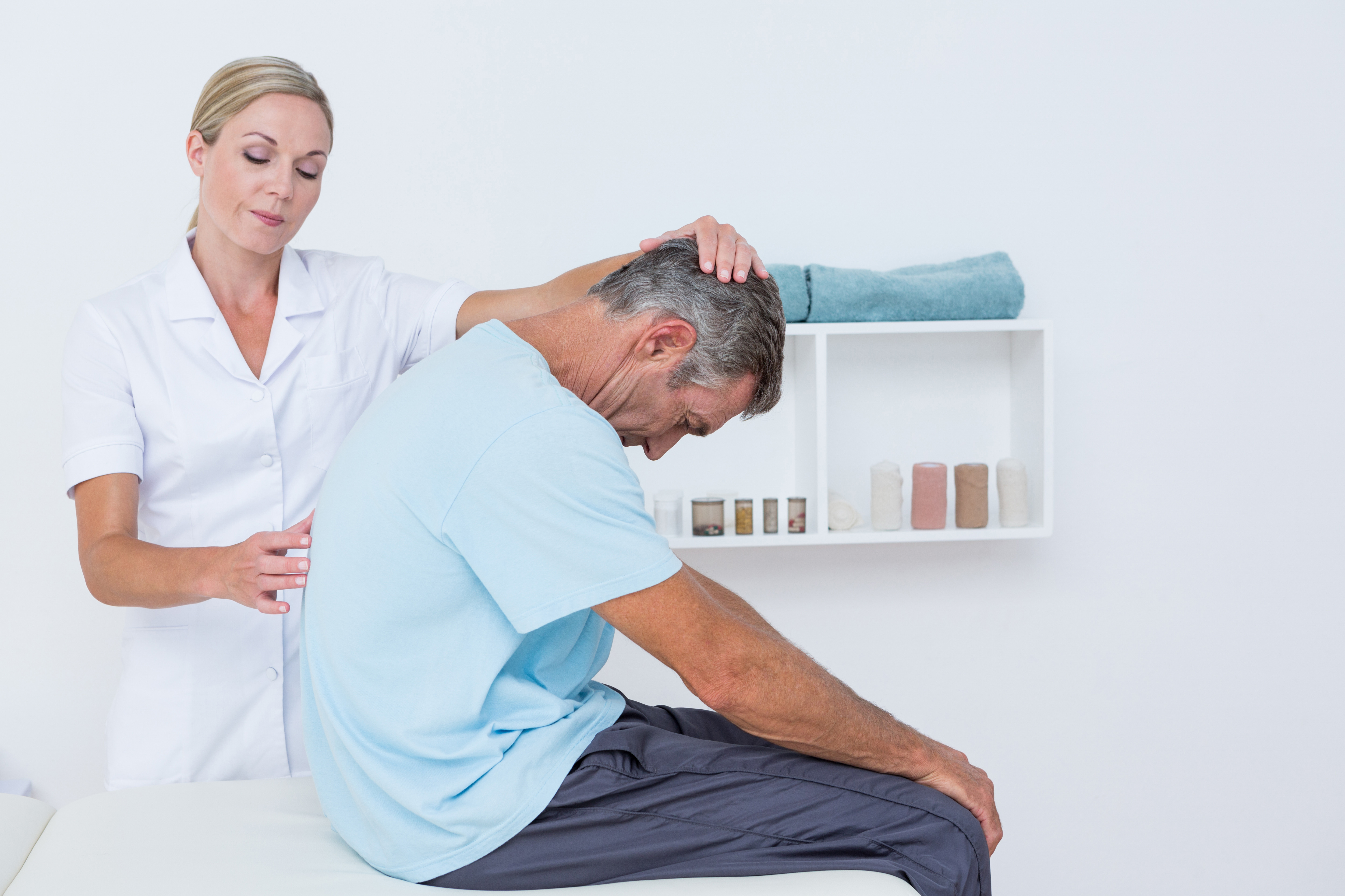 Doctor stretching a man back in medical office